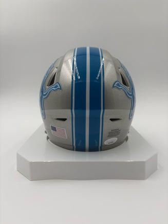 Silver and blue football helmet on a white stand with a gray background