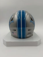 Silver football helmet with blue stripes on a white stand against a white background