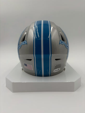 Silver football helmet with blue stripes on a white stand against a white background