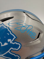 Silver football helmet with blue logo and signature on a gray background